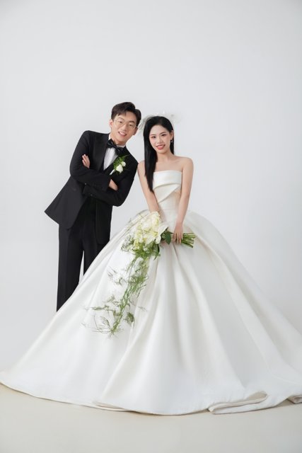 纯白背景下两人相依的全身婚纱照